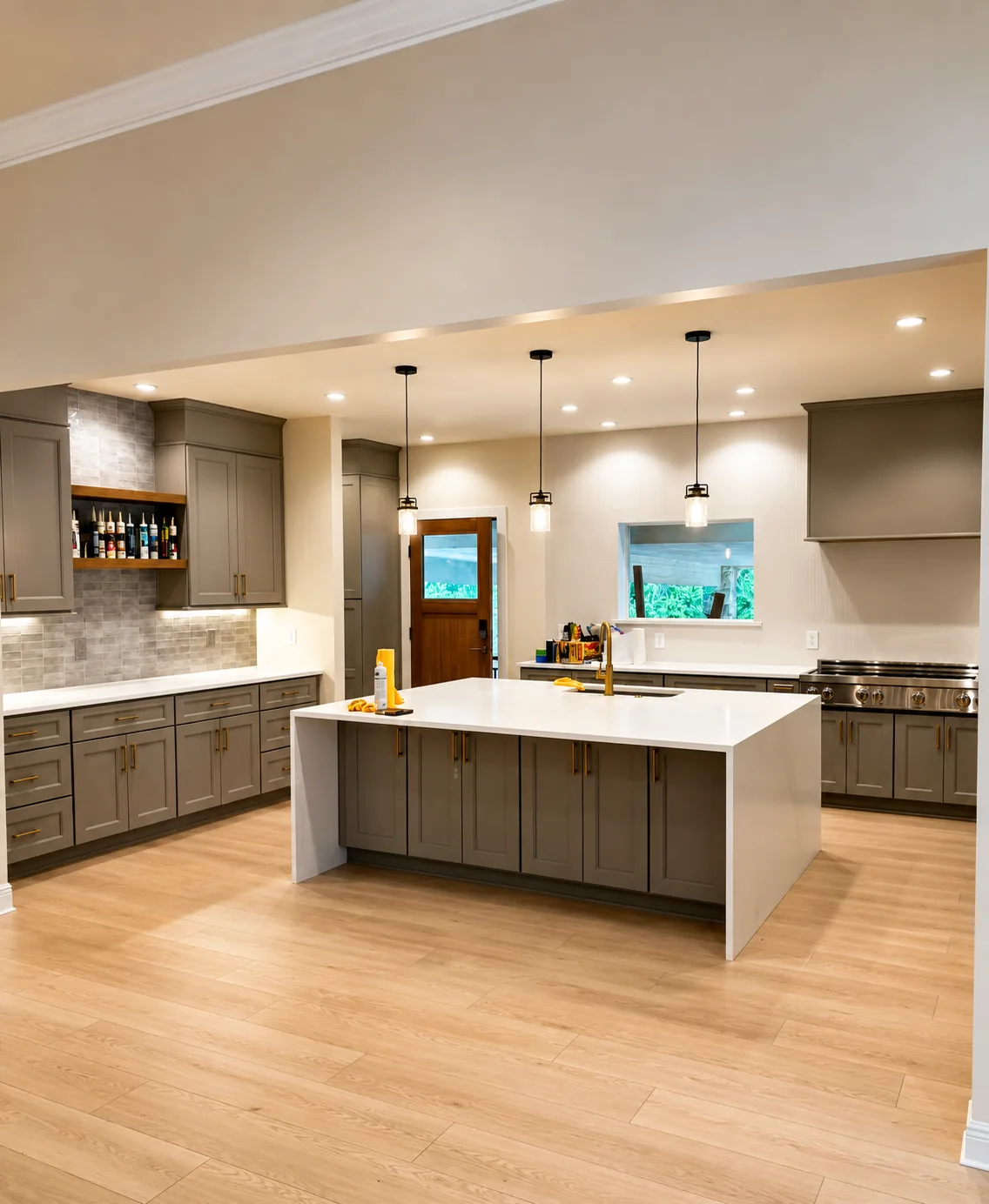 Kitchen with gray cabinetry, a white island countertop, pendant lights, and wood flooring